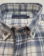 Detalle del cuello abotonado de la camisa de cuadros azules