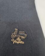 Detalle del emblema bordado de la camisa azul marino La Vespita