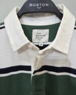 Detalle del cuello y etiqueta del polo de rayas verdes Boston