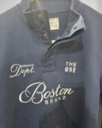 Detalle del cuello con botones y estampado de la sudadera Boston