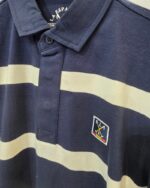 Detalle del cuello y emblema del polo azul marino La Española