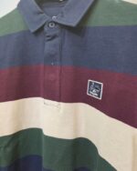 Detalle del cuello, franjas y parche del polo multicolor La Vespita