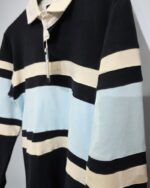 Detalle de las franjas y el cuello del polo celeste José Beltrán